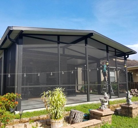 patio enclosure repair in Ocala, FL with technician fixing screened structure